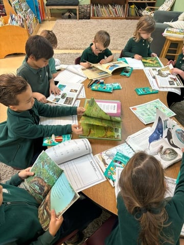 1st graders reading studying books together at a table